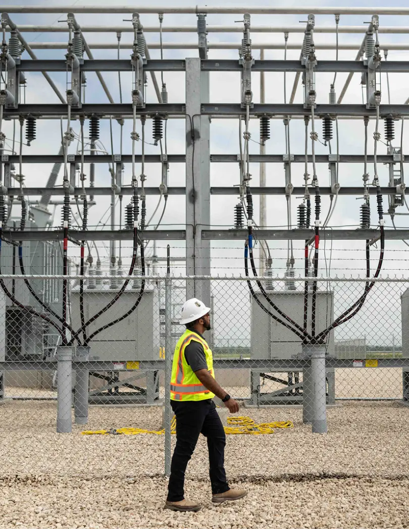 Construction worker walking in front of a substation